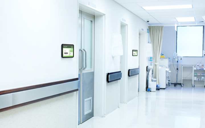 iPad digital door sign outside hospital patient room with IPORT mount