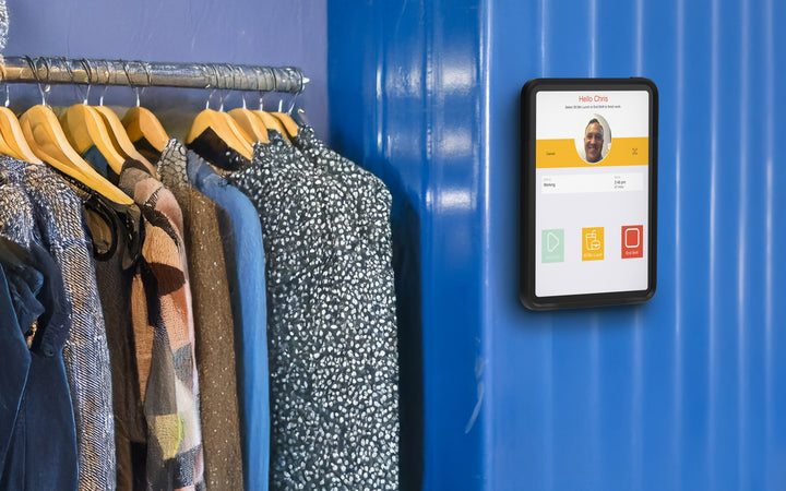 Retail employee clocking in with facial recognition on a wall-mounted iPad biometric time clock