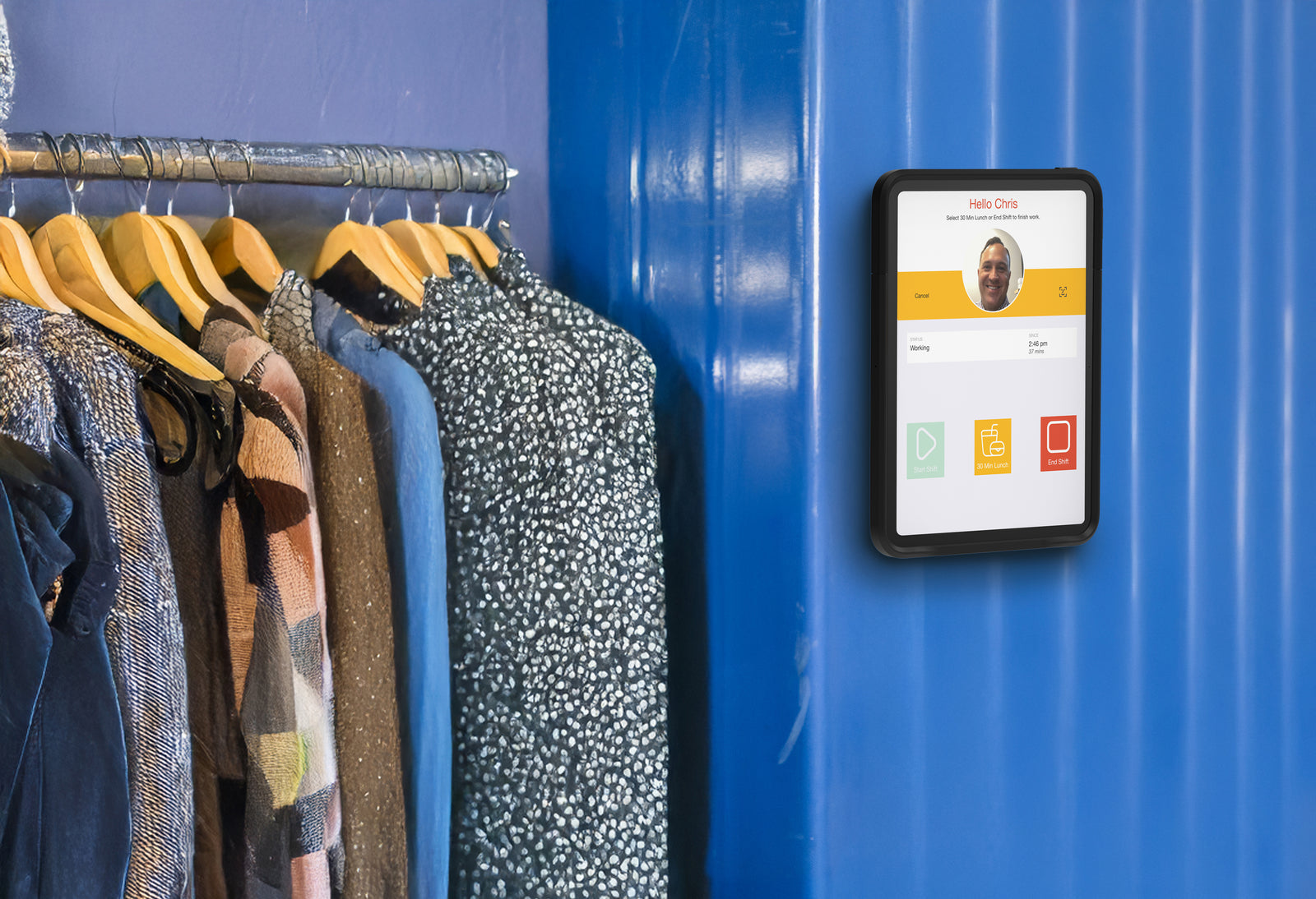 Retail employee clocking in with facial recognition on a wall-mounted iPad biometric time clock