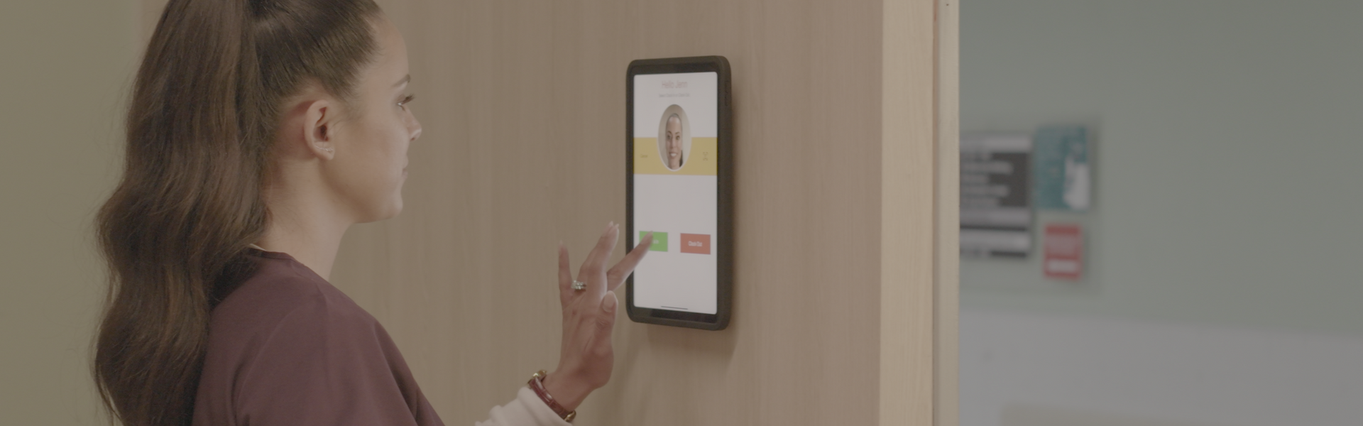 Healthcare worker using iPad biometric time clock with IPORT wall mount